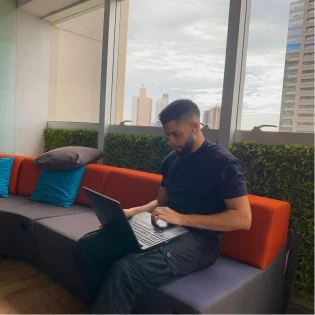 Igor Souza working on a laptop at the office balcony
